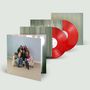 Ein Cover zeigt eine Gruppe von Menschen auf einem Sofa mit Plüschtieren. Zwei rote Vinylplatten sind teilweise sichtbar., 2 LPs
