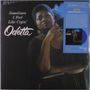 "Sometimes I Feel Like Cryin' Odetta". Frau hält Zigarette, ernster Blick, dunkel gekleidet, blaues Info-Label rechts.