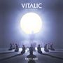 „Vitalic“ und „Rave Age“. Eine große Gestalt hält ein leuchtendes Objekt, umgeben von knienden Menschen.