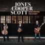„JONES COOPER SCOTT WHO WRITES THE STORY“ steht oben. Drei Männer halten Instrumente vor einem Gebäude.