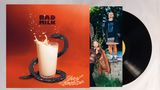 "BAD MILK" und "Meast Machine" in fetter Schrift. Ein Glas Milch mit Schlange, daneben zwei Personen in auffälliger Kleidung., LP