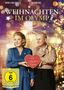"Weihnachten im Olymp", FSK ab 6. Zwei Personen, Frau in blauem Kleid hält Herz mit "Kaufhaus Olymp". Festliche Beleuchtung., DVD
