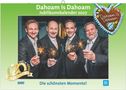 Text im Bild: "Dahoam is Dahoam", "Jahreskalender 2026", "Vorjahresabbildung", "Lansing is a Gfui". Drei lachende Personen.