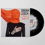 „Sarah Lesch“, „Poesie & Widerstand“. Frau mit orangefarbenem Tuch, schwarze Kleidung, Vinyl-Schallplatte sichtbar., LP