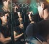 Texte: "ZOODRAKE", "reunite". Ein Mann blickt in zersplitterte Spiegelstücke, wodurch sein Gesicht mehrfach reflektiert wird., CD