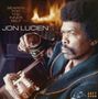 „SEARCH FOR THE INNER SELF“, „JON LUCIEN“. Ein Mann mit Gitarre, angestrengter Blick, knisternder Kamin im Hintergrund., CD