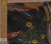 Japanischer Text auf orangefarbenem Streifen, Sonnenblumenfeld bei Sonnenuntergang, ausgestreckter Arm., CD