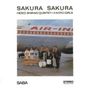 "Sakura Sakura" steht oben. "Hideo Shiraki Quintet + 3 Koto Girls" darunter. Menschen mit Musikinstrumenten vor einem Flugzeug., LP