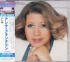 "Aretha Franklin" und japanische Schriftzeichen. Frau mit glatt gestyltem Haar lächelt sanft, ihr Kopf ruht auf einer Hand.