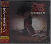 „Ozzy Osbourne Blizzard of Ozz“. Person mit dunklem Umhang kniet auf Holzboden, im Hintergrund diffuse Lichtquelle.