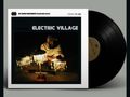 Auf einem Schallplattencover steht oben "The Sound Environment Recording Series", darunter "Electric Village". Ein Mann mit Turban sitzt bei Lampen., LP