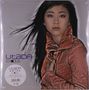 „Utada Exodus“ in lila und grauer Schrift. Eine Frau mit langen, dunklen Haaren trägt eine orange Jacke.