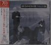 "John Scofield Trio LIVE EnRoute" steht auf einem dunklen Cover. Drei Männer in Schwarz auf einem Flugzeugflügel., CD