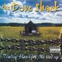 "The Dove Shack" oben, "Reality Has Got Me tied up" unten. Ein kleines Haus steht in einem Feld, Ketten im Vordergrund., CD