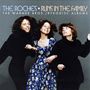 "The Roches • Runs in the Family. Drei Frauen lächelnd, eine in einem blauen Blumenmusterkleid, die anderen in Schwarz.", 3 CDs