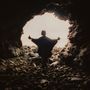 Kein Text vorhanden. Silhouette einer Person mit ausgebreiteten Armen steht am Eingang einer felsigen Höhle, Licht im Hintergrund., CD