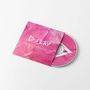 Text auf der pinken Verpackung: "PLAY". Ein CD-Cover mit abstraktem Design in weiß und pink., CD