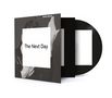 Text "The Next Day" zentral auf weißem Quadrat. Schwarz-weiße Fotografie im Hintergrund, CD leicht herausgezogen.