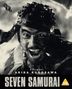 Text: "A FILM BY AKIRA KUROSAWA. SEVEN SAMURAI. PG". Schwarz-weißes Filmposter mit einem kämpfenden Krieger.