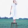 Keine erkennbaren Texte. Eine Person steht barfuß auf einem Hocker in einem weißen Kleid und hält eine Rose in der Hand., LP