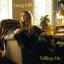Text: "Lucy Kitt" und "Telling Me". Eine Frau sitzt nachdenklich in einem Sessel, umgeben von Büchern und einer Pflanze., CD