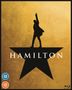 Text: "HAMILTON". Eine schwarze Silhouette steht auf einem Stern, den Arm nach oben gestreckt, vor goldenem Hintergrund.
