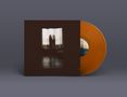 Eine orangefarbene Vinyl-Schallplatte mit einem Albumcover. Das Cover zeigt eine Silhouette vor einem erleuchteten Fenster., LP