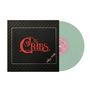 Schwarzes Cover mit rotem Text "The Cribs" und "Selling A Vibe". Grüne Schallplatte mit rosa Label rechts daneben., LP