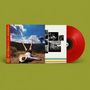 Ein rotes Vinyl mit einem Albumcover: Eine Person liegt rücklings in der Natur, die Beine in die Luft gestreckt., LP