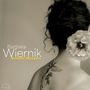 Texte: "Barbara Wiernik, Between Whispers". Frau mit Tattoo und großer Blume im Haar, sepiafarben., CD