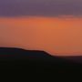 Kein Text erkennbar. Eine Silhouette eines Hügels vor einem Himmel in lila und orange während des Sonnenuntergangs., CD