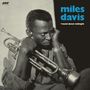 „Miles Davis, 'round about midnight“. Schwarz-weißes Porträt: Ein ernster Trompeter stützt den Kopf in beide Hände.