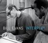 Text: "BILL EVANS INTERPLAY". Ein Mann mit Sonnenbrille schreibt, ein anderer spielt Bass. Schwarz-weiß, Studioumgebung.