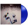 "PHILIP GLASS" in großen Buchstaben, darüber ein Kristallmotiv. Eine blaue Vinylschallplatte ist rechts sichtbar.
