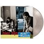 Text: "hier zijn Acda en de Munnik." Zwei Männer in einem Raum, einer sitzt am Tisch, der andere steht mit Händen am Gesicht. Vinylalbum daneben., LP