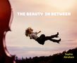 Text: "THE BEAUTY IN BETWEEN" und "Sophie Abraham". Eine Person in bunter Kleidung scheint in der Luft zu schweben, neben einem Cello., CD