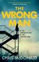 "The Wrong Man. In the wrong place at the wrong time… Chris McDonald." Silhouette einer Person auf einer Treppe vor Skyline., Buch