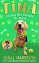 Tina: The Dog Who Changed The World von Niall Harbison. Ein fröhlicher Hund mit einem bunten Halstuch., Buch