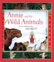 "Annie and the Wild Animals". Ein Kind steht von Tieren umgeben im Schnee. Roter Rand mit Tierpfoten-Design.