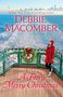 „DEBBIE MACOMBER, A Ferry Merry Christmas“. Eine Frau in einem roten Mantel steht auf einer Fähre mit einem Kranz.