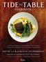 „Tide to Table Cookbook“: Ein Teller mit Fisch, Erbsen, Spargel und Muscheln auf einer Holztisch-Optik., Buch