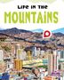 "Life in the Mountains", "Janine Deschenes". Hochhäuser vor Berglandschaft, Logo unten rechts., Buch