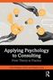 Text: "Applying Psychology to Consulting: From Theory to Practice". Grafik: Hände halten Glühbirnen, Erde im Hintergrund., Buch