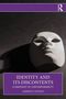 Buchtitel: "Identity and Its Discontents". Autorenname: "Alberto Castelli". Weiße Maske auf dunklem Hintergrund., Buch