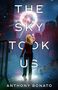 "The Sky Took Us" von Anthony Bonato. Eine Frau steht in einer Stadt und streckt die Hand zu einem leuchtenden Objekt im Himmel., Buch
