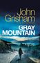 „Gray Mountain“ von John Grisham, New York Times Bestseller. Eine Frau wandert auf einem Pfad in einer Berglandschaft.