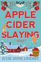 „APPLE CIDER SLAYING“ in Rot, darunter „A CIDER SHOP MYSTERY“. Winterliche Landschaft mit Haus und Katzen., Buch