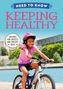 Text oben: "Need to Know Keeping Healthy." Ein Mädchen mit rosa Helm fährt lächelnd Fahrrad am Wasser.