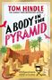 Das Cover zeigt den Titel "A Body in the Pyramid" von Tom Hindle. Rote und schwarze Schrift; Palmen, Skulpturen, Wüstenkulisse., Buch