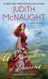 "Judith McNaught, A Kingdom of Dreams." Eine Frau in rotem Kleid vor einer weitläufigen Landschaft mit Burg im Hintergrund.